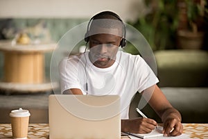 Hombre agotador auriculares seguimiento creación partitura estudiar conectado a internet 