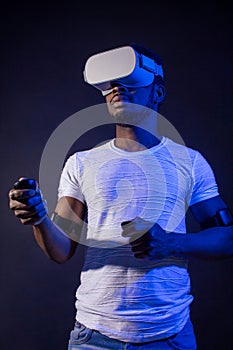 African Man in white, wearing VR Headset on green blue dual color background.