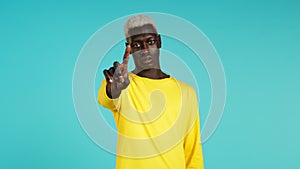African man in yellow disapproving with no finger sign make negation gesture. Denying, Rejecting, Disagree, Portrait of