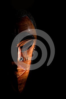 African mask. Travel souvenirs isolated on black background
