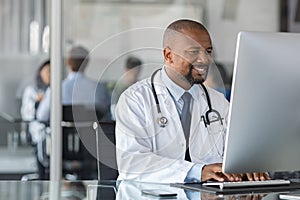 African mature doctor working on computer photo