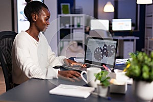 African mechanical designer working on computer late at night