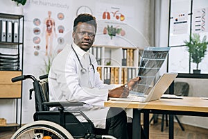 African medical worker in wheelchair checking x ray scan