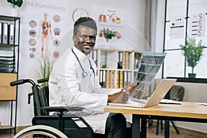 African medical worker in wheelchair checking x ray scan