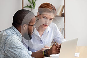 African mentor consultant explaining computer work to caucasian intern client