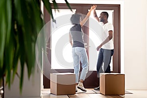 African millennial couple dancing at hallway on moving day