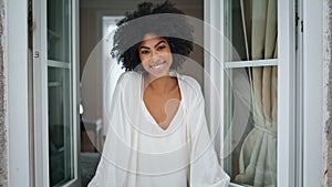 African model looking window at home portrait. Positive woman catching raindrops
