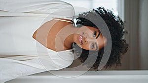 African model looking window at home portrait. Woman catching raindrops vertical
