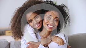 African mother and daughter embracing smiling looking at camera