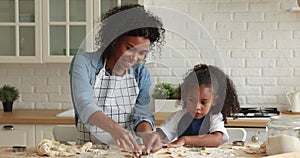 African mother and daughter preparing cookies in the kitchen