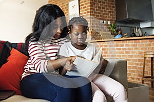 African mother helping her daughter in doing her homework photo