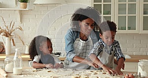 African mother and kids preparing cookies in the kitchen