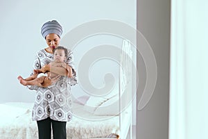 African mother raising a happy baby in the house