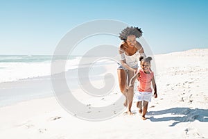 African mother running after her daughter on the beach