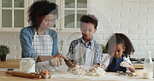 African mother their little kids cooking together in the kitchen