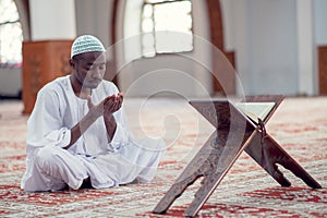 African Muslim Man Making Traditional Prayer To God While Wearing Dishdasha photo