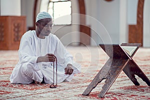 African Muslim Man Making Traditional Prayer To God While Wearing Dishdasha photo