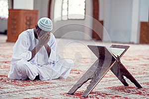 African Muslim Man Making Traditional Prayer To God While Wearing Dishdasha photo