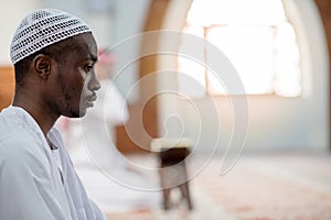 African Muslim Man Making Traditional Prayer To God While Wearing Dishdasha photo