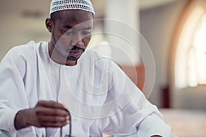 African Muslim Man Making Traditional Prayer To God While Wearing Dishdasha photo