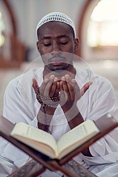 African Muslim Man Making Traditional Prayer To God While Wearing Dishdasha photo