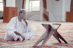 African Muslim Man Making Traditional Prayer To God While Wearing Dishdasha photo