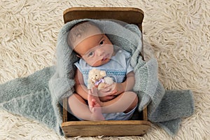 African newborn baby in tiny wooden bed