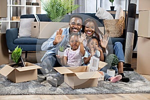 African parents with kids smiling and waving at new flat