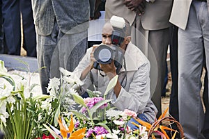 african photographer taking pictures at a funeral