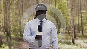 African reporter with face medical mask and gloves in the forest