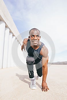 African runner preparing to start on concrete road