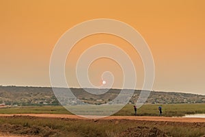 African rural people returning from work, with sunset. Sumbe. An