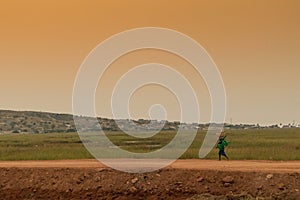 African rural people returning from work, with sunset. Sumbe. An