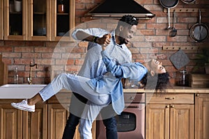 African 35s couple in love dancing in kitchen at home photo