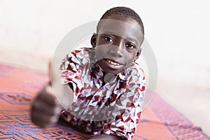 African schoolboy giving the thumbs up in front of White Background