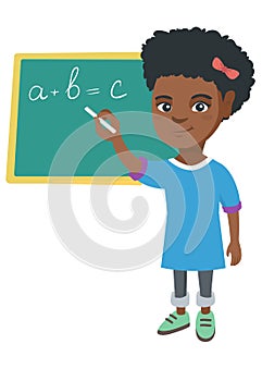 African schoolgirl writing on the blackboard.