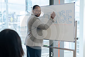 African senior male calculus professor is writing on whiteboard in the classroom