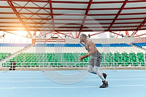 African shirtless spotsman running at the stadium