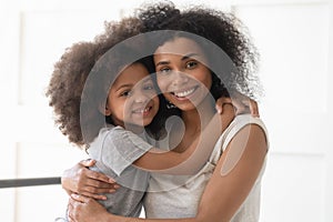 African single mother and child daughter embrace looking at camera photo