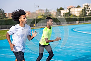 African sportsmen running along a athletics track