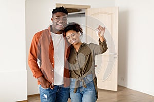 African Spouses Showing House Key Standing Among Moving Boxes Indoor