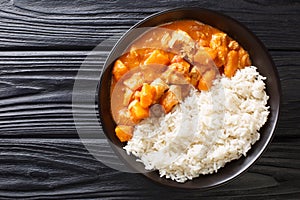 African stew Domoda with peanuts cooked with chicken pumpkin and served with rice close-up in a plate. Horizontal top view