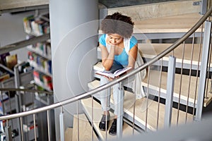 African student girl reading book at library