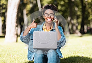 African Student Woman With Laptop Gesturing Thumbs Up Sitting Outside