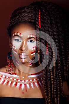 African style . Attractive young woman in ethnic jewelry . close up portrait of a woman with a painted face. Creative make up