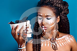 African style . Attractive young woman in ethnic jewelry . close up portrait of a woman with a painted face. Creative make up