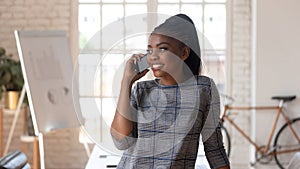 African successful businesswoman talking on phone at workplace