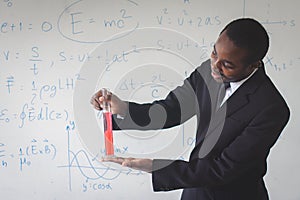 African teacher is explaining science lessons inside the classroom with a  scientific equations in background