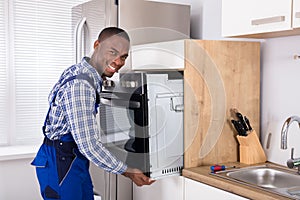 African Technician In Overall Installing Oven