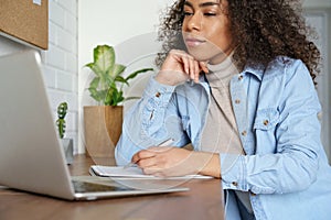 African teen girl college student elearning at home making notes. Closeup